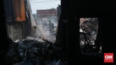 Warga mengais benda dan material sisa rumah mereka setelah si jago merah melahap pemukiman kumuh Kampung Walang, Pademangan. Dugaan sementara penyebab kebakaran adalah korsleting listrik dari salah satu rumah warga, Minggu (26/8). (CNN Indonesia/Andry Novelino).