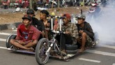 Penggemar Vespa ekstrem menempuh perjalanan jauh dari Semarang menuju Kediri demi menghadiri acara 'Kediri Scooter Festival 2018'. (REUTERS/Darren Whiteside)