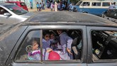 Berseragam lengkap dengan tas di punggungnya, anak-anak itu terlihat semangat menyambut hari pertama di tahun ajaran ini. (AFP Photo/Mahmud Hams)