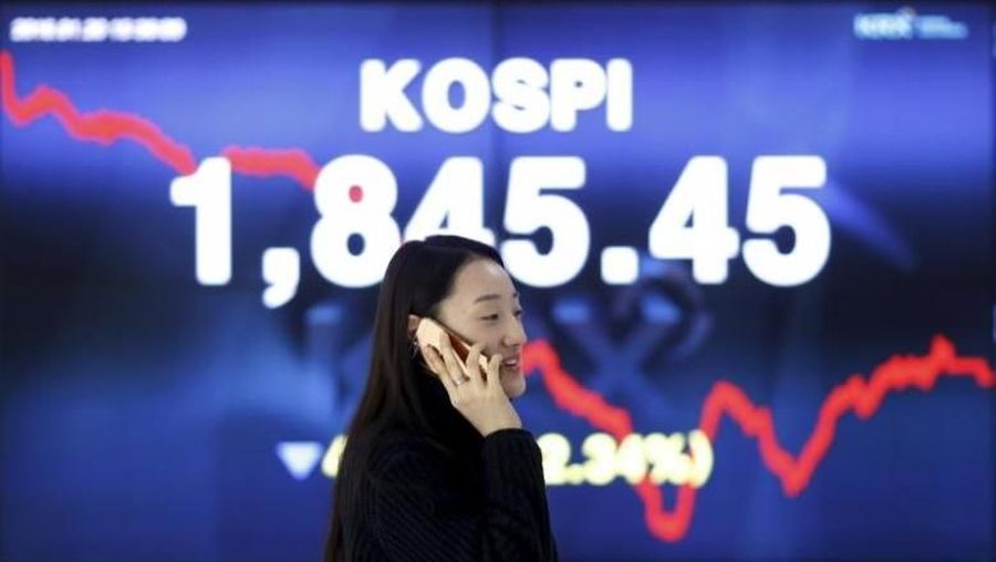A woman talking on the phone walks past an electronic board of the Korea Composite Stock Price Index (KOSPI) at the Korea Exchange (KRX) in Seoul, South Korea, January 20, 2016 REUTERS/Kim Hong-Ji