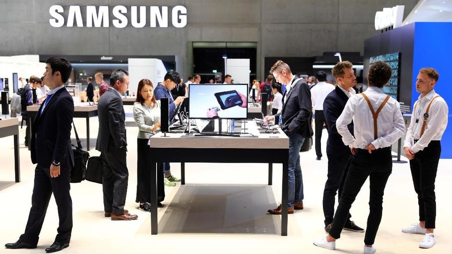 Visitors in front of a Samsung logo during the preview day of the IFA trade show for consumer electronics and home appliances, in Berlin, Germany August 30, 2018.   REUTERS/Christian Mang