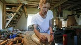 Fedynsky saat mengerjakan pembuatan alat musik tradisional Ukraina di bengkelnya.