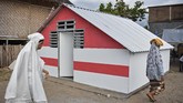 Sejumlah warga melintas di dekat bangunan Rumah Hunian Sementara yang dibangun BUMN di Posko Pengungsian Desa Kekait, Kecamatan Gunungsari, Lombok Barat, NTB, Senin (27/8). (ANTARA FOTO/Ahmad Subaidi)