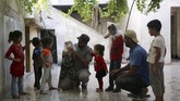 Ia kemudian tersenyum menatap anaknya yang kini sudah siap menghadapi segala kemungkinan keracunan zat kimia ketika pertempuran antara pasukan pemerintah dan pemberontak memanas. (Reuters/Khalil Ashawi)