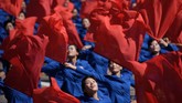 Para peserta parade yang melambaikan bendera dalam gelaran selebrasi hari jadi ke-70 Korea Utara. (AFP PHOTO / Ed JONES)
