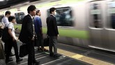 Para pekerja sedang menanti kereta cepat di stasiun kereta (AFP PHOTO / Behrouz MEHRI)