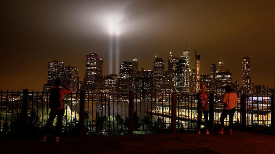 People look at the Tribute in Light installation as it illuminates lower Manhattan as seen from the borough of Brooklyn, marking the 17th anniversary of the 9/11 attacks in New York City, U.S., September 11, 2018. REUTERS/Brendan McDermid.