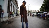 Seorang tukang bangunan bernama Francisco Valdez sedang menanti prosesi Virgin of Regla di area pantai Regla, sebuah distrik di pelabuhan Havana, Kuba. (REUTERS/Alexandre Meneghini)
