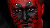 Seorang penggemar timnas Albania dicat wajahnya kala mendukung kesebelasan tersebut di laga melawan Skotlandia di Glasgow. (REUTERS/Russell Cheyne)