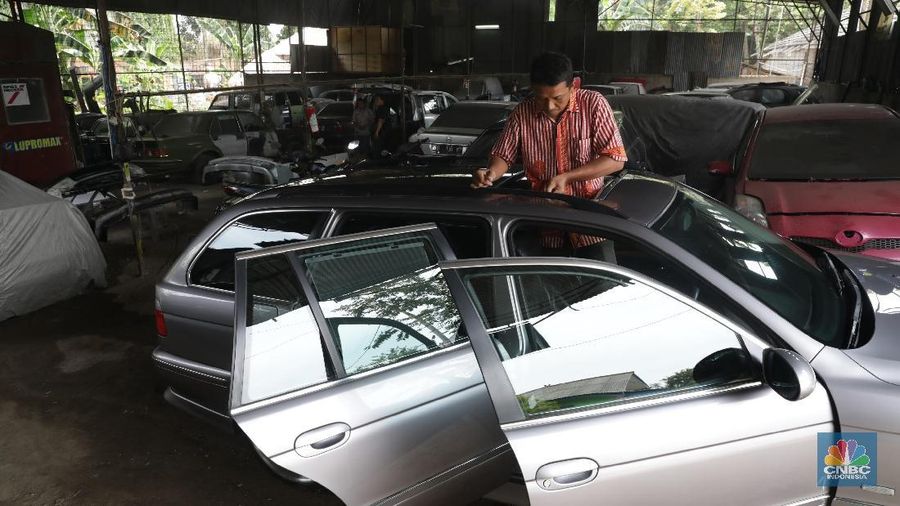 Pekerja menyelesaikan pemasangan atap mobil di bengkel mobil di kawasan, Tangerang, Banten, Jumat (14/9). Perusahaan-perusahaan asuransi membatasi usia kendaraan yang boleh diikutsertakan dalam program asuransi. Asuransi kendaraan yang bisa dipilih, comprehensive untuk pergantian apabila beberapa bagian mobil rusak atau keserempet. Atau bisa juga total loss only untuk pergantian apabila mobil hilang. Asuransi kan terima mobil sampai usia mobil 9 tahun untuk comprehensive atau 15 tahun untuk TLO (total loss only).  (CNBC Indonesia/Muhammad Sabki)