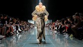 Ikatan rosette berukuran besar pada celana panjang satin, gaun tartan dengan banyak lapisan, dan tak lupa permainan ruffles yang dihadirkan membuat busana yang dipamerkan itu seolah 'meledak'. (REUTERS/Andrew Kelly)