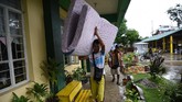 Keluarga di Cagayan mengangkut semua barang dari dalam rumahnya agar tidak terkena banjir yang akan dibawa Topan Mangkhut ketika tiba di wilayah itu pada Sabtu (22/9) pagi. (AFP Photo/Ted Aljibe)