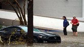 Orang-orang berusaha melewati banjir yang mampir di kota mereka, Wilmington. Banjir itu datang dibawa oleh Badai Florence yang menerpa sebagian kota di Carolina Utara. (REUTERS/Carlo Allegri)
