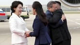 Didampingi istri masing-masing, kedua pemimpin saling menyapa sebelum mengikuti upacara penyambutan militer. (Pyeongyang Press Corps/Pool via Reuters)
