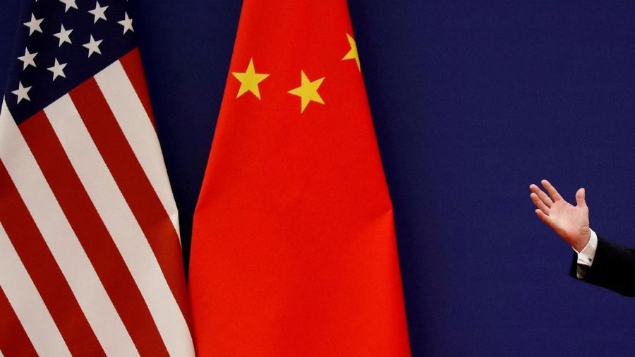 FILE PHOTO: U.S. President Donald Trump delivers his speech next to U.S. and Chinese flags as he and Chinese President Xi Jinping meet business leaders at the Great Hall of the People in Beijing, China, November 9, 2017. REUTERS/Damir Sagolj/File Photo