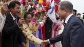 Di sekitar mereka, terlihat ratusan warga bersorak, mengibarkan bendera Korut dan lambang unifikasi yang menunjukkan peta Semenanjung Korea. (Pyeongyang Press Corps/Pool via Reuters)