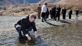 Bersama istri mereka, Kim dan Moon berjalan mengitari daerah itu dan berfoto bersama. Moon bahkan sempat mengisi botol minumnya dengan air dari danau tersebut. (Pyeongyang Press Corps/Pool via Reuters)