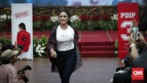 Artis Krisdayanti berjalan berbalut pakaian yang didesain khusus untuk generasi milenial. Diharapkan, atribut itu memikat generasi muda bahwa politik itu menyenangkan.(CNNIndonesia/Safir Makki)