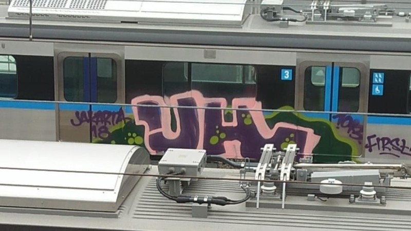 Coretan graffiti pada badan luar kereta nomor tiga di rangkaian kereta kedelapan (K1 1 18 45) MRT Jakarta.