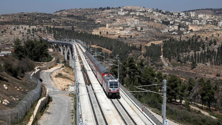 The Palestinian village of Beit Iksa in the occupied West Bank is seen in the background as Israel's new high-speed rail line travels on its tracks in Jerusalem September 25, 2018. REUTERS/Ammar Awad