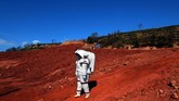 Presenter televisi Perancis, Eglantine Emey, mengenakan pakaian luar angkasa berjalan-jalan di Vitrolles, dekat kota Marseille, dalam acara program TV Moonwalk. Tujuan program itu adalah mengembangkan dan menguji teknologi serta prosedur latihan untuk misi manusia ke bulan dan mars. (AFP PHOTO / BORIS HORVAT)