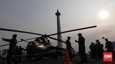 Anggota TNI berjaga di depan Helikopter saat pameran Alat Utama Sistem Persenjataan di Monumen Nasional, Jakarta, Kamis (27/9). (CNN Indonesia/Adhi Wicaksono)