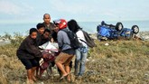 Warga bersama-sama membawa korban gempa sesaar setelah gempa melanda di Palu dan Donggala. (AFP PHOTO / MUHAMMAD RIFKI)