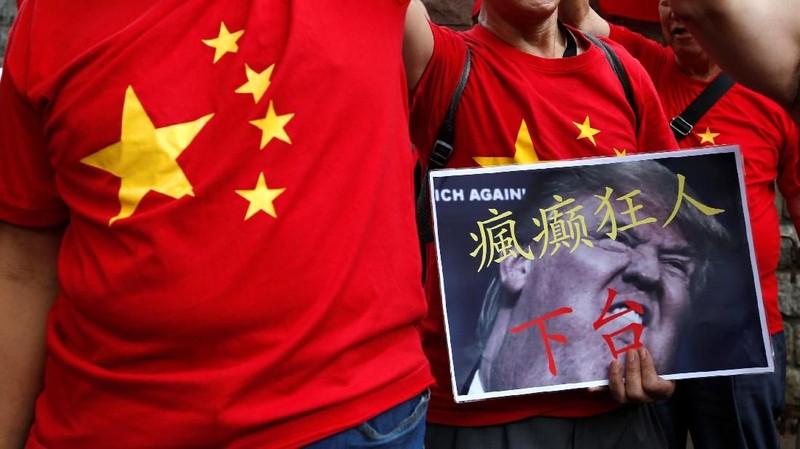 Perang dagang Amerika Serikat dan China memicu protes dan pembakaran iPhone di depan kedutaan AS di Hong Kong.