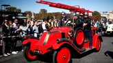 Peserta mengendarai kendaraan pemadam kebakaran berpartisipasi dalam parade Place de la Concorde bagian dari pameran otomotif Paris Motor Show ke-120 di Paris, Prancis. (REUTERS/Benoit Tessier)