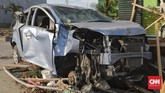 Orang-orang tidak bertangung jawab melepas sebagian komponen mobil yang menurut mereka masih bisa digunakan. Kejadian ini di sekitar Palu Grand Mall, Palu, Sulawesi Tengah, Rabu, 3 Oktober 2018. (CNN Indonesia/Adhi Wicaksono)