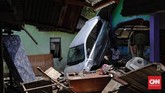 Sebuah mobil tampak tertumpuk berdiri di dinding rumah akibat terjangan tsunami. (CNNIndonesia/Adhi Wicaksono)