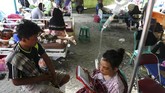 Seorang pasien korban gempa dan tsunami Sulteng memanfaatkan waktu membaca kitab suci di sebuah rumah sakit darurat di Kota Palu, 4 Oktober 2018. (REUTERS/Athit Perawongmetha)