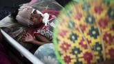Seorang bocah laki-laki korban gempa dan tsunami Sulteng terbaring lemas di ranjang perawatan medis di sebuah rumah sakit lapangan di Kota Palu, 4 Oktober 2018. (REUTERS/Athit Perawongmetha)