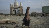 Seorang warga melintas di depan bangunan Masjid Arkham Babu Rahman yang hancur dan terhempas tsunami Palu. (AFP PHOTO/Mohd Rasfan)