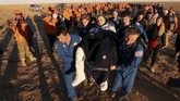 Personil darat membawa awak pesawat Ruang Angkasa Internasional (ISS) Ricky Arnold dari AS sesaat setelah pendaratan kapsul ruang angkasa Soyuz MS-08. (Maxim Shipenkov/Pool via REUTERS)