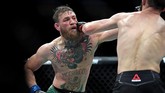 Conor McGregor berupaya melepaskan pukulan untuk merobohkan Khabib Nurmagomedov dalam sebuah partarungan atas. (Stephen R. Sylvanie-USA TODAY Sports)