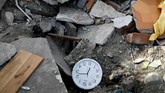 Jam dinding teronggok di puing-puing bangunan yang hancur diguncang gempa magnitudo 7,7. Diperkirakan lebih dari 5 ribu bangunan rusak setelah gempa dan tsunami menerjang. (REUTERS/Jorge Silva)