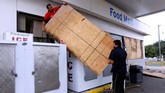 Pemilik toko p[un memasang penutup pada pintu dan jendela mereka sebagai antisipasi ketika badai menerjang (REUTERS/Jonathan Bachman)