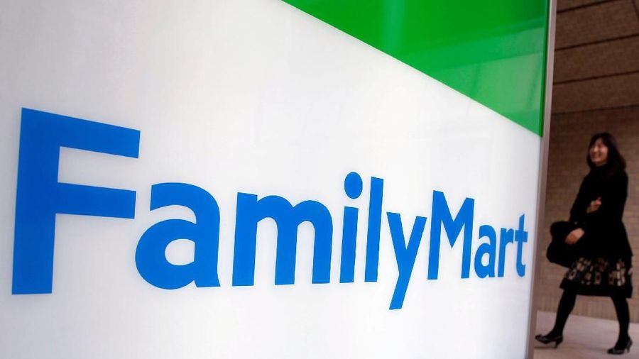 FILE PHOTO: A woman walks into a FamilyMart convenience store in Tokyo November 25, 2010.  REUTERS/Yuriko Nakao/File Photo