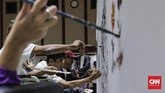 Dengan semangat, para seniman ini menuangkan imajinasi mereka melalui goresan cat di atas kanvas. (CNNIndonesia/Adhi Wicaksono.)