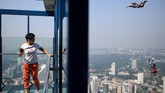 Seorang wisatawan yang sedang berada di menara Kuala Lumpur, menyaksikan para base jumper (sebutan bagi orang yang melakukan kegiatan base jumping) sedang beraksi.