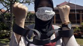Peserta aksi yang tergabung dalam Gerakan Rakyat Menentang IMF-World Bank melakukan unjuk rasa di depan Polda Bali. (ANTARA FOTO/Fikri Yusuf).