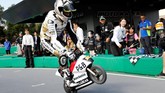 Pebalap Angel Nieto Team Alvaro Bautista melakukan wheelie dalam balapan sepeda motor mini. (REUTERS/Toru Hanai)