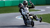 Pebalap Angel Nieto Team Alvaro Bautista memboncengi seorang penggemar usai balapan motor mini di Motegi. (REUTERS/Toru Hanai)