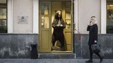 Di Moskow, seorang perempuan berjalan melewati toko yang di depan pintu masuknya terdapat boneka beruang yang sedang menawarkan vodka. (Photo by Mladen ANTONOV / AFP)