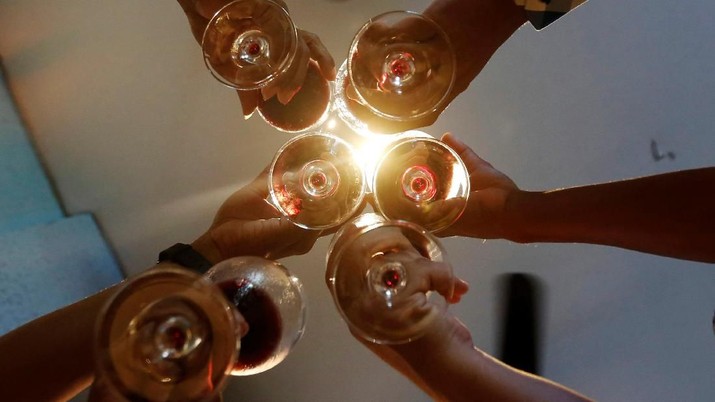 Men toast with their glasses of wine at a restaurant in Phnom Penh, Cambodia, October 18, 2018. REUTERS/Samrang Pring