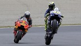 Valentino Rossi (kanan) dan pebalap Red Bull KTM Pol Espargaro. Latihan bebas kedua MotoGP Jepang tidak berjalan maksimal karena kondisi trek yang masih basah usai diguyur hujan. (REUTERS/Toru Hanai)
