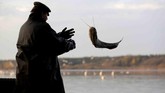 Seorang pemancing tradisional melemparkan ikan carp di danau dekat kota Trebon, Kota Ceko. (REUTERS/David W Cerny)