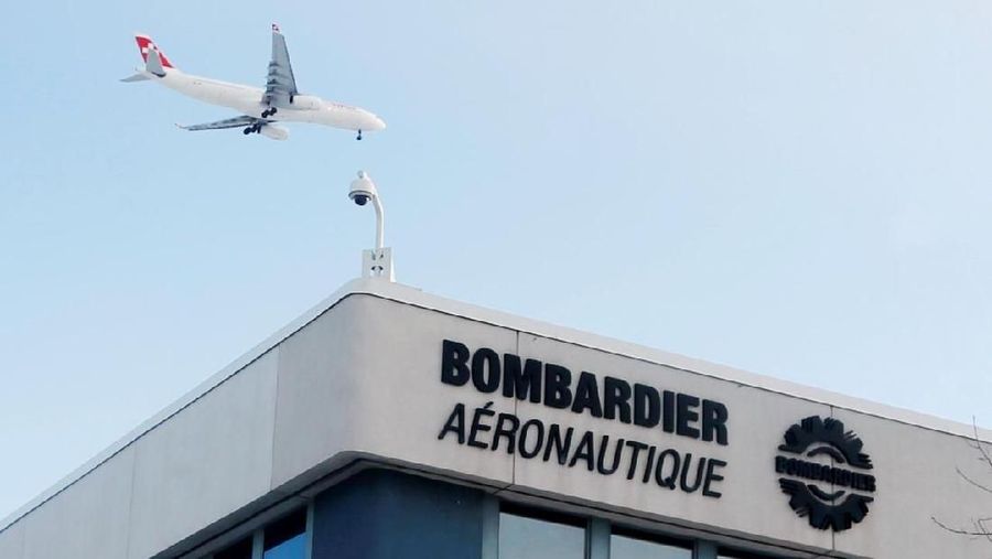 FILE PHOTO: A plane flies over a Bombardier plant in Montreal, Quebec, Canada on January 21, 2014. REUTERS/Christinne Muschi/File Photo