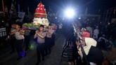 Warga menyaksikan tumpeng raksasa diarak saat Istighosah Akbar di Masjid Nasional Al Akbar, Surabaya, Jawa Timur, Kamis (18/10) malam. Kegiatan bertema Untuk Indonesia Aman, Damai dan Sejuk itu untuk menyambut Hari Santri Nasional. (ANTARA FOTO/Didik Suhartono)